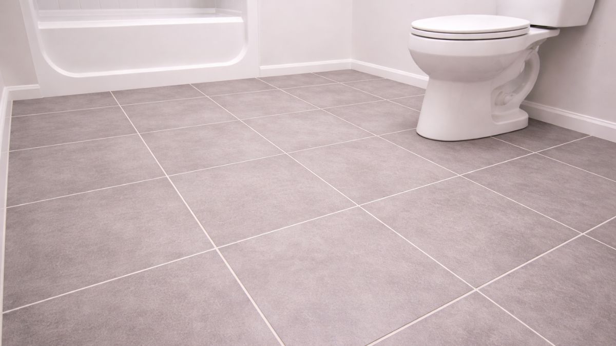 Completed tiled bathroom floor with grout sealed and toilet reinstalled